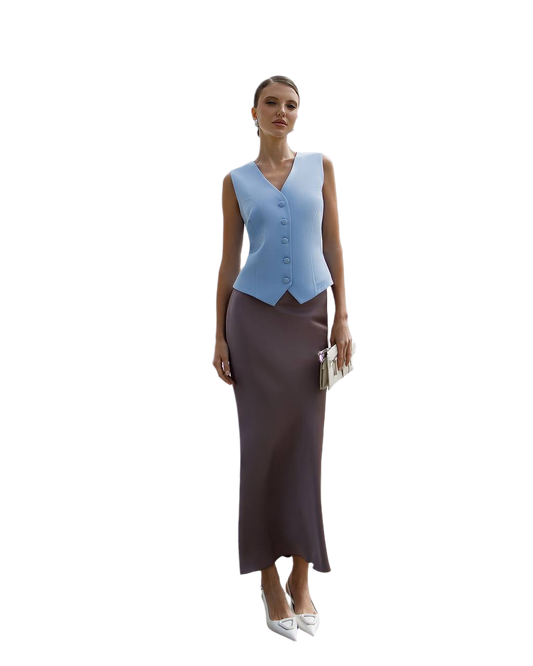 Woman wearing a light blue vest over a brown dress on a white background