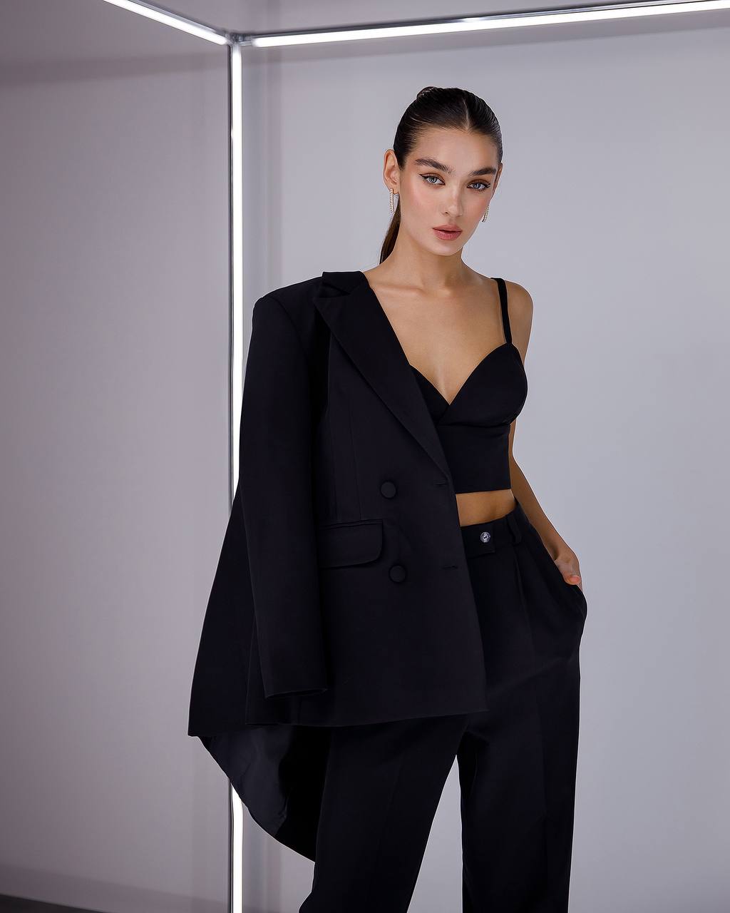 Woman wearing a black suit with a plain background