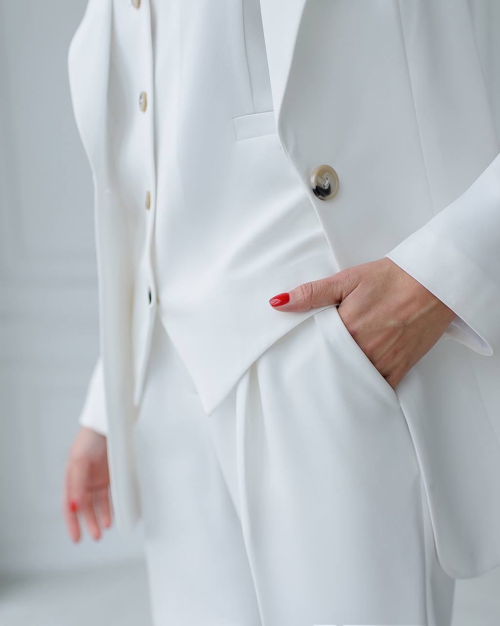 Person wearing a white suit with a plain background