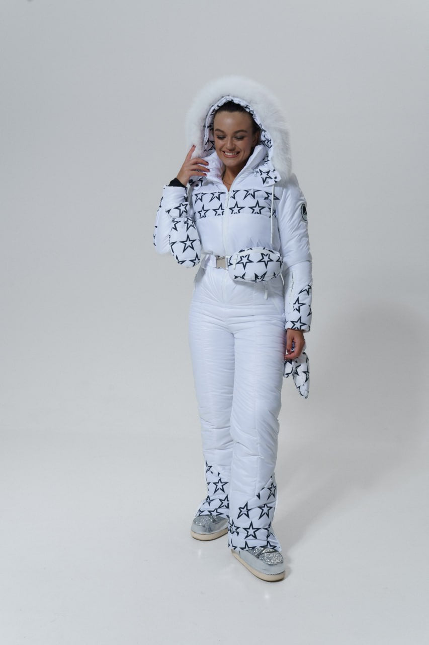 Person wearing a white snowsuit with star patterns on a plain background
