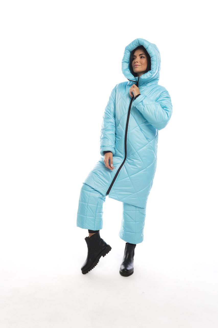 Person wearing a blue quilted jumpsuit on a white background