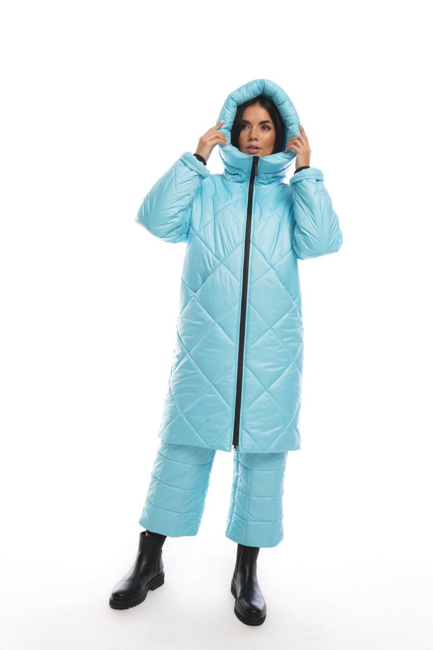 Person wearing a light blue quilted jumpsuit on a white background