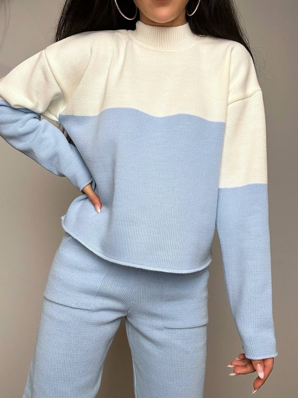 Two-tone sweater with cream and light blue colors on a neutral background