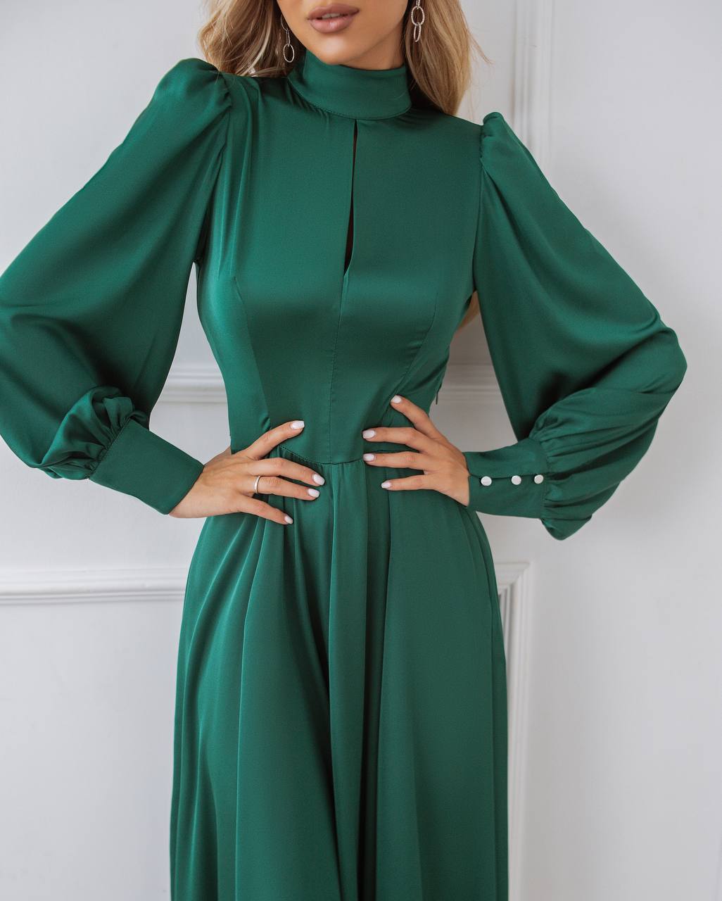 Green dress with long sleeves and a high neckline on a white background