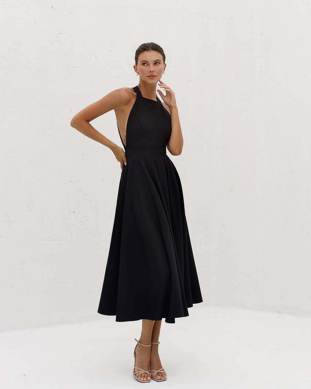 Woman wearing a black dress against a white background