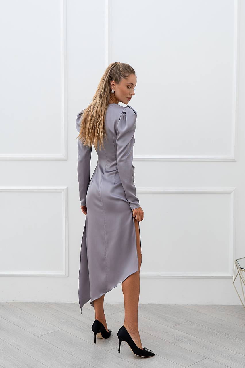 Woman wearing a gray dress with a white wall background