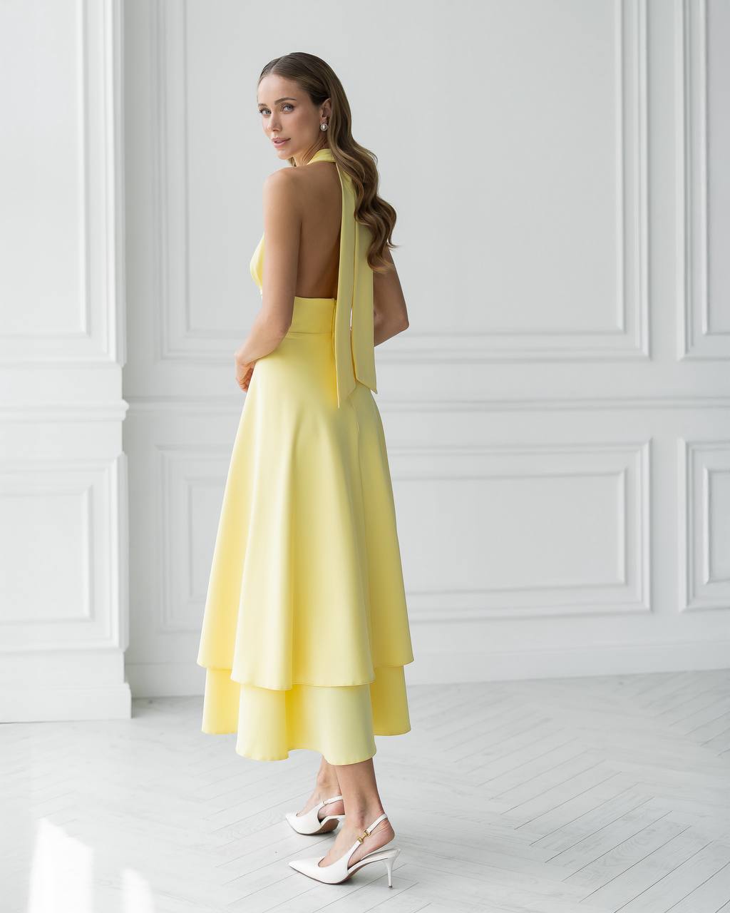 Woman wearing a yellow dress with a white background