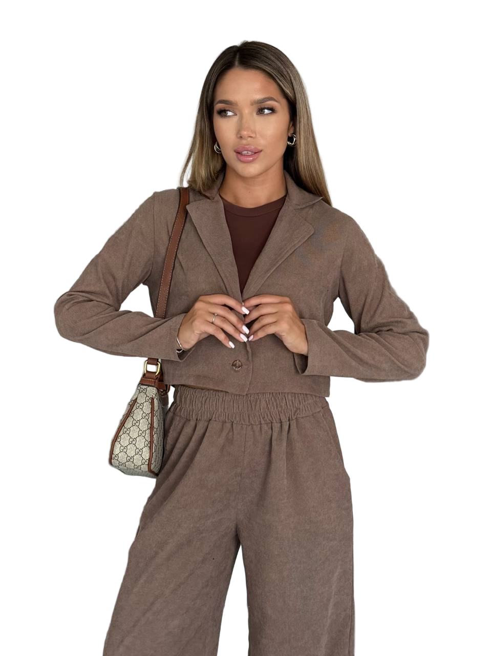 Woman wearing a brown outfit with a matching handbag on a white background