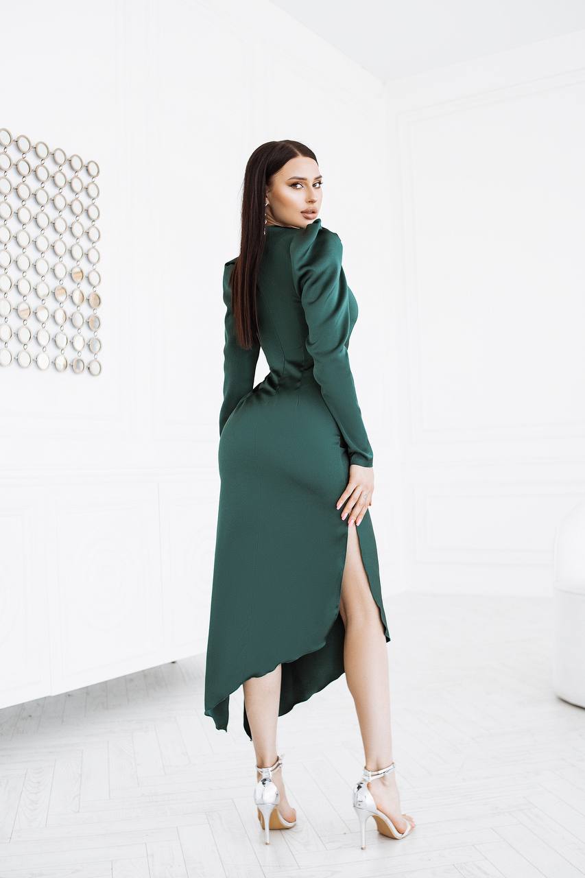 Woman wearing a green dress with a high slit on a white background