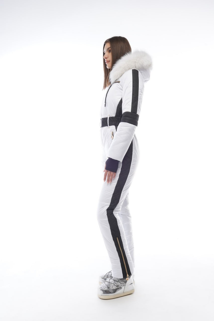 Person wearing a white and black snowsuit with fur trim on a white background