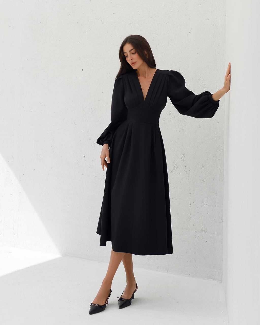 Woman wearing a black dress against a white background