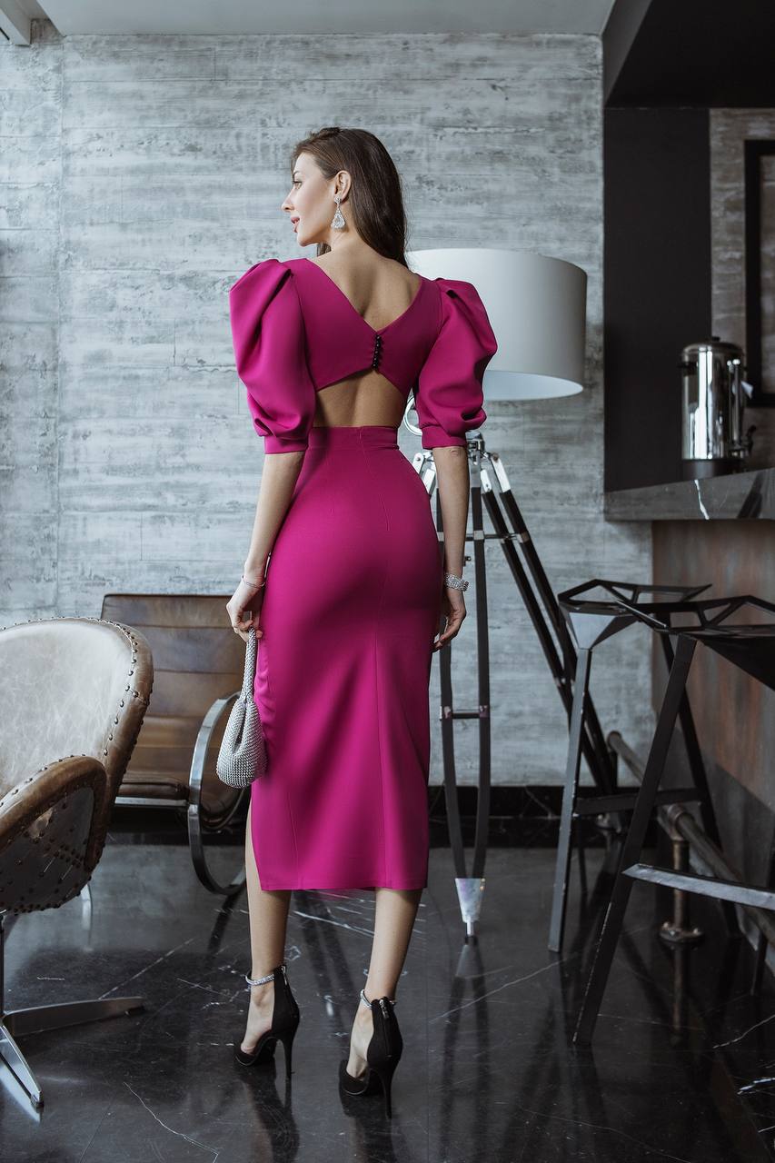 Woman in a pink dress standing in a modern interior setting