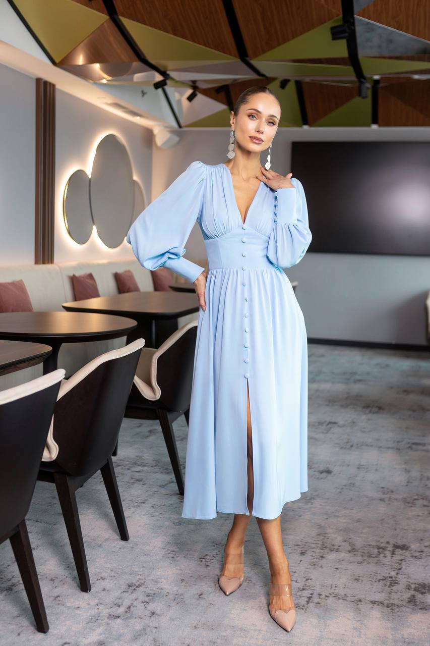 Woman in a light blue dress standing in a modern restaurant setting