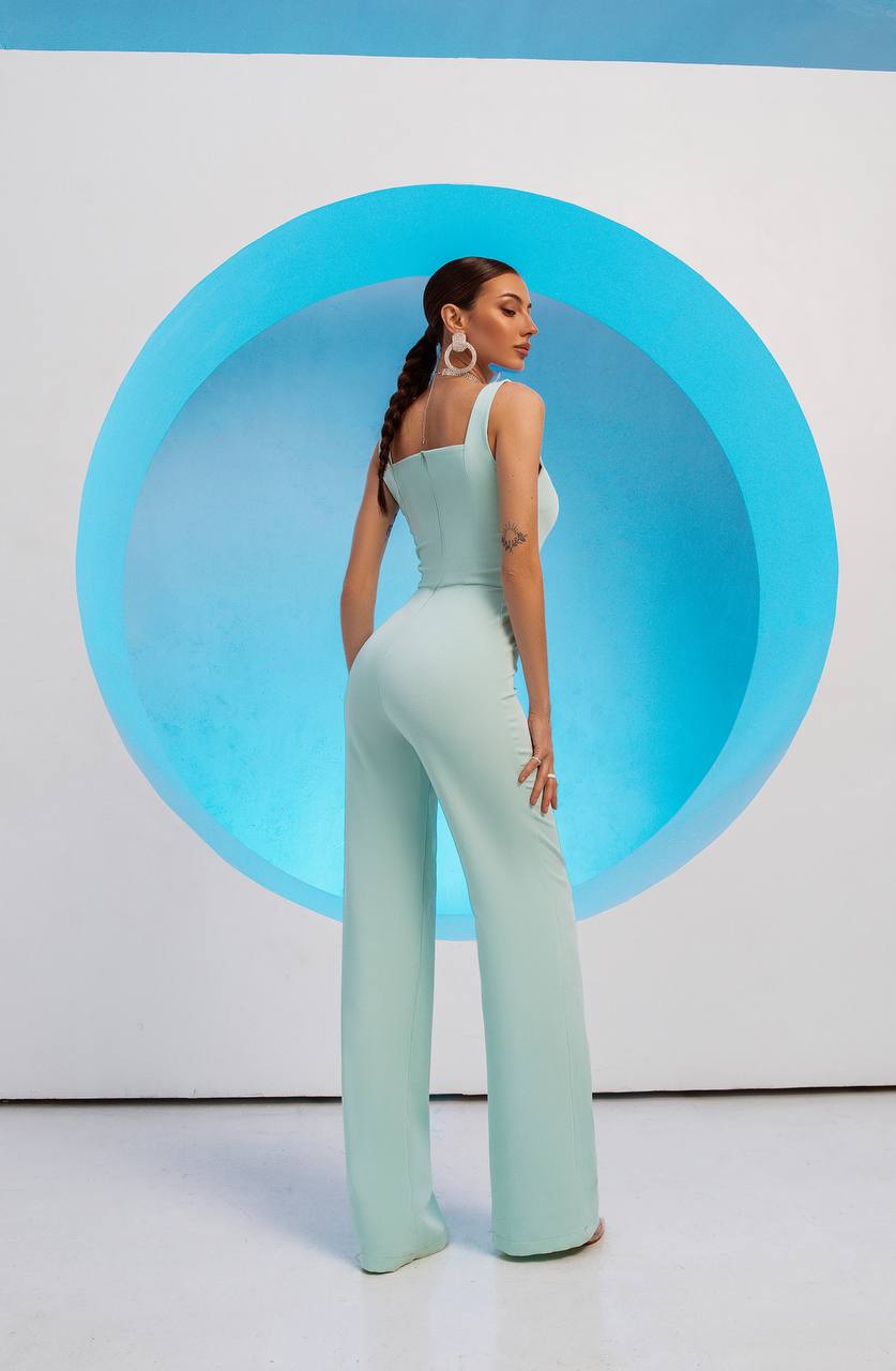 Woman in a light blue outfit standing in front of a blue circular design on a white background