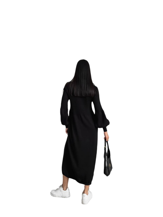 Person wearing a black dress holding a black handbag on a white background