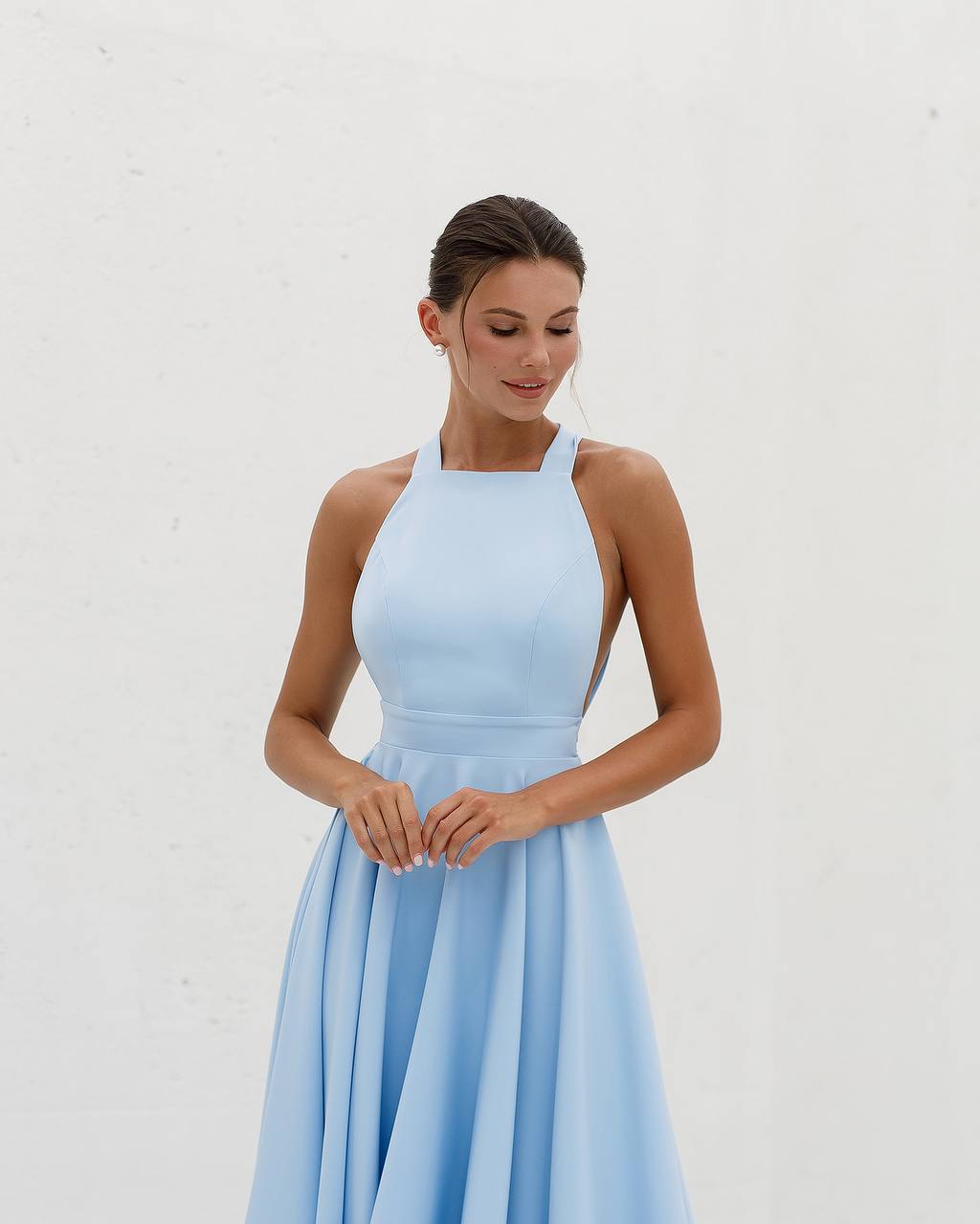 Woman wearing a light blue dress against a white background