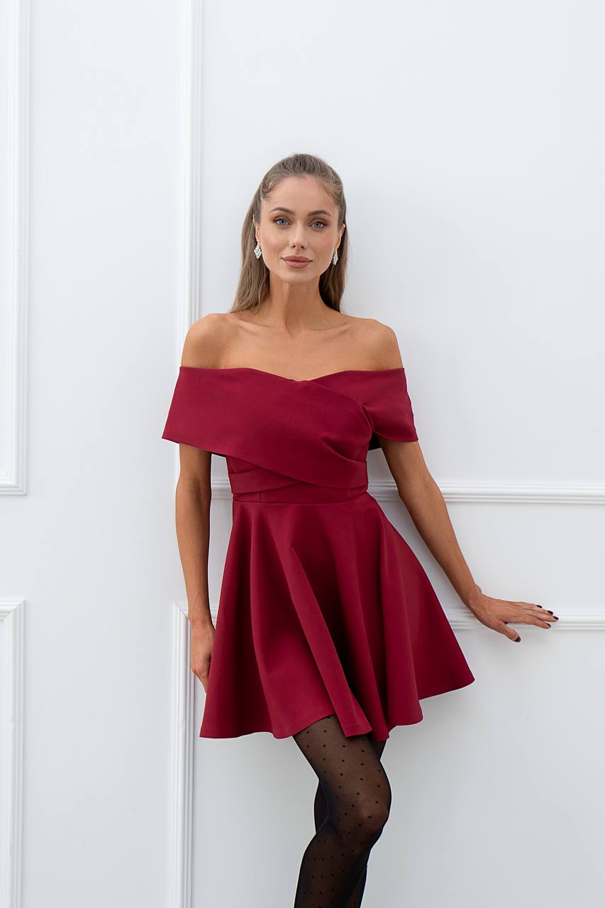 Woman wearing a red off-shoulder dress against a white background