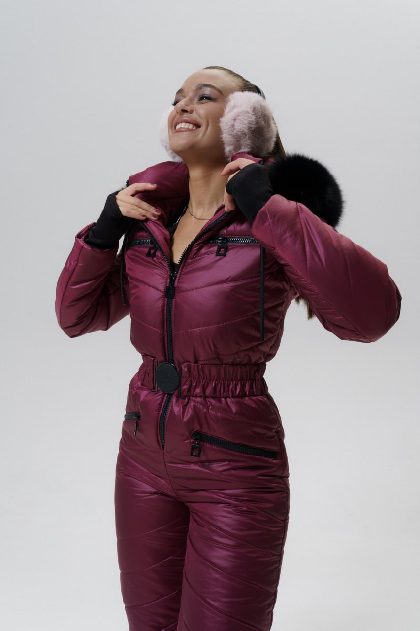 Person wearing a maroon snowsuit with black accents on a white background