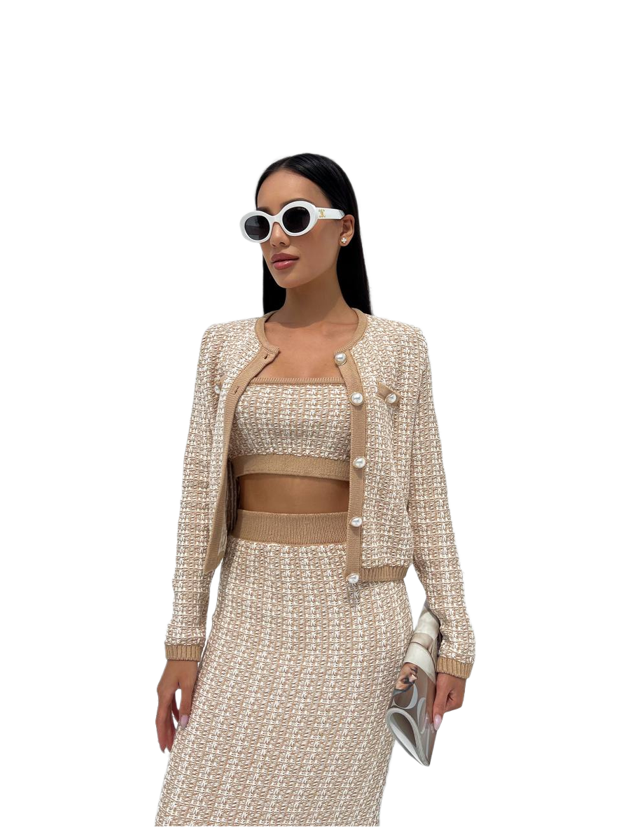 Woman wearing a beige and white outfit with sunglasses on a white background