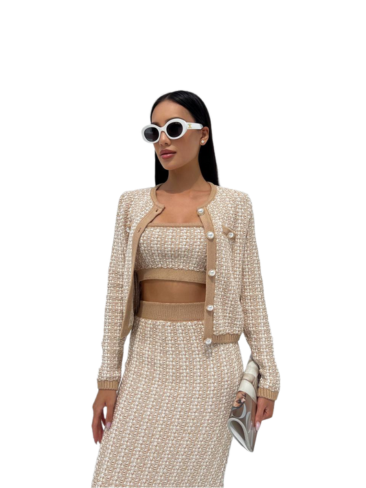 Woman wearing a beige and white outfit with sunglasses on a white background