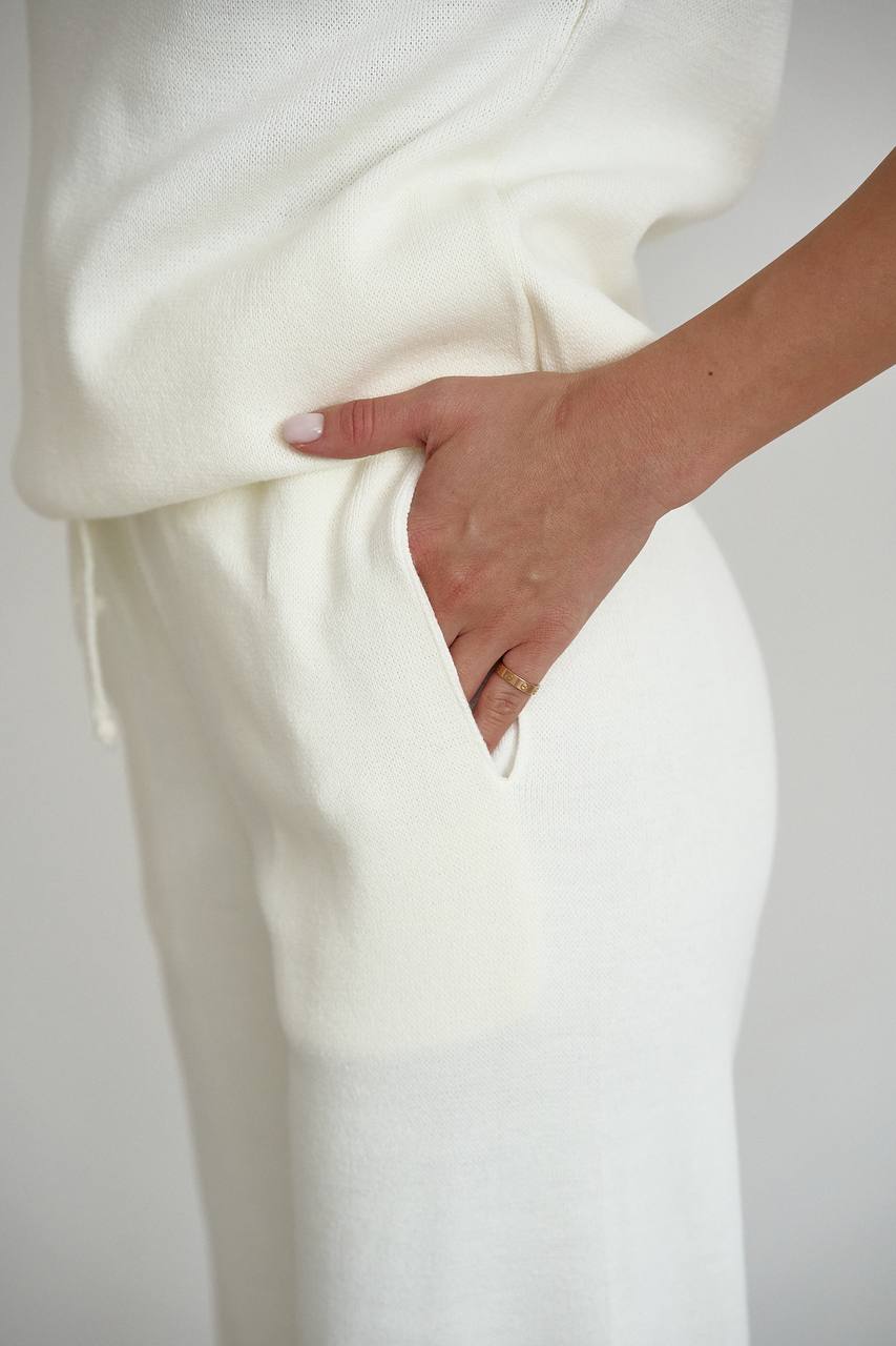 Person wearing a white outfit with a plain background