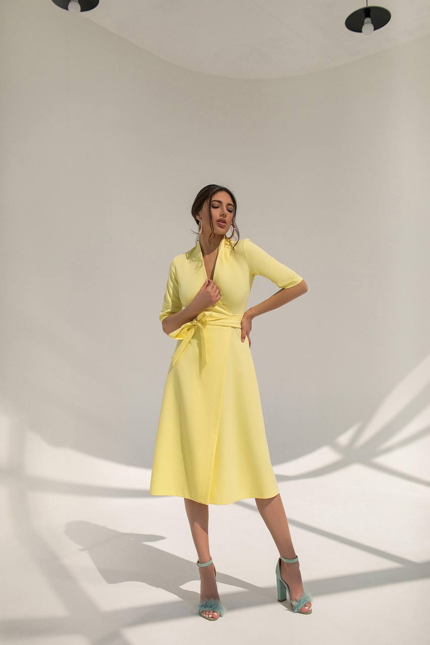Woman wearing a yellow dress in a studio setting