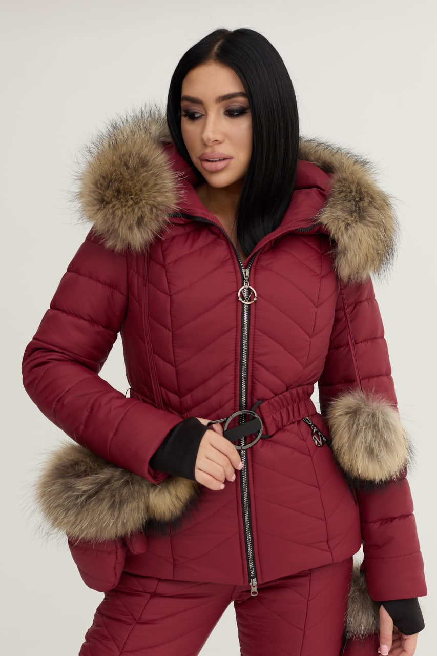 Red puffer jacket with fur trim worn by a model on a white background