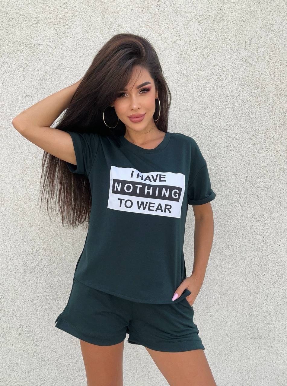 Woman wearing a black t-shirt with 'I HAVE NOTHING TO WEAR' text against a light gray background