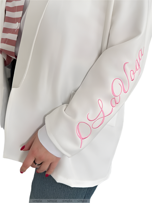 White sweatshirt with pink embroidery on sleeve, worn by a person.