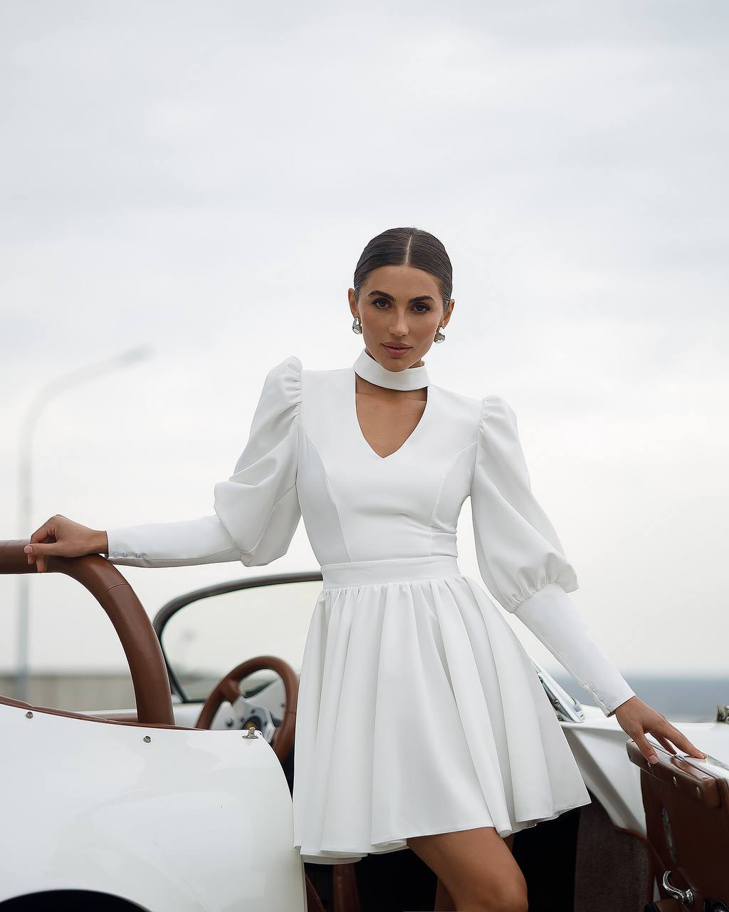 Woman in a white dress standing on a boat with a white background