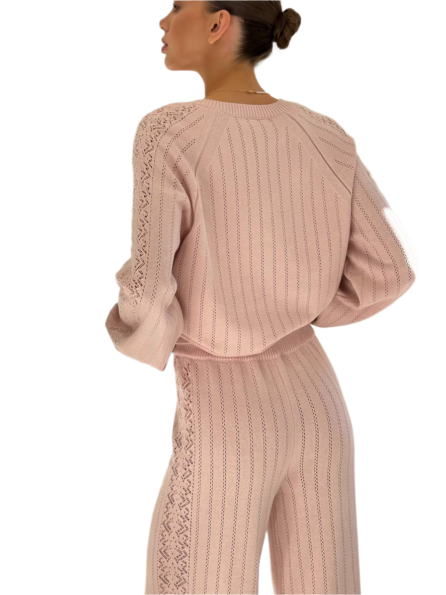 Pink knit outfit with lace details on a white background