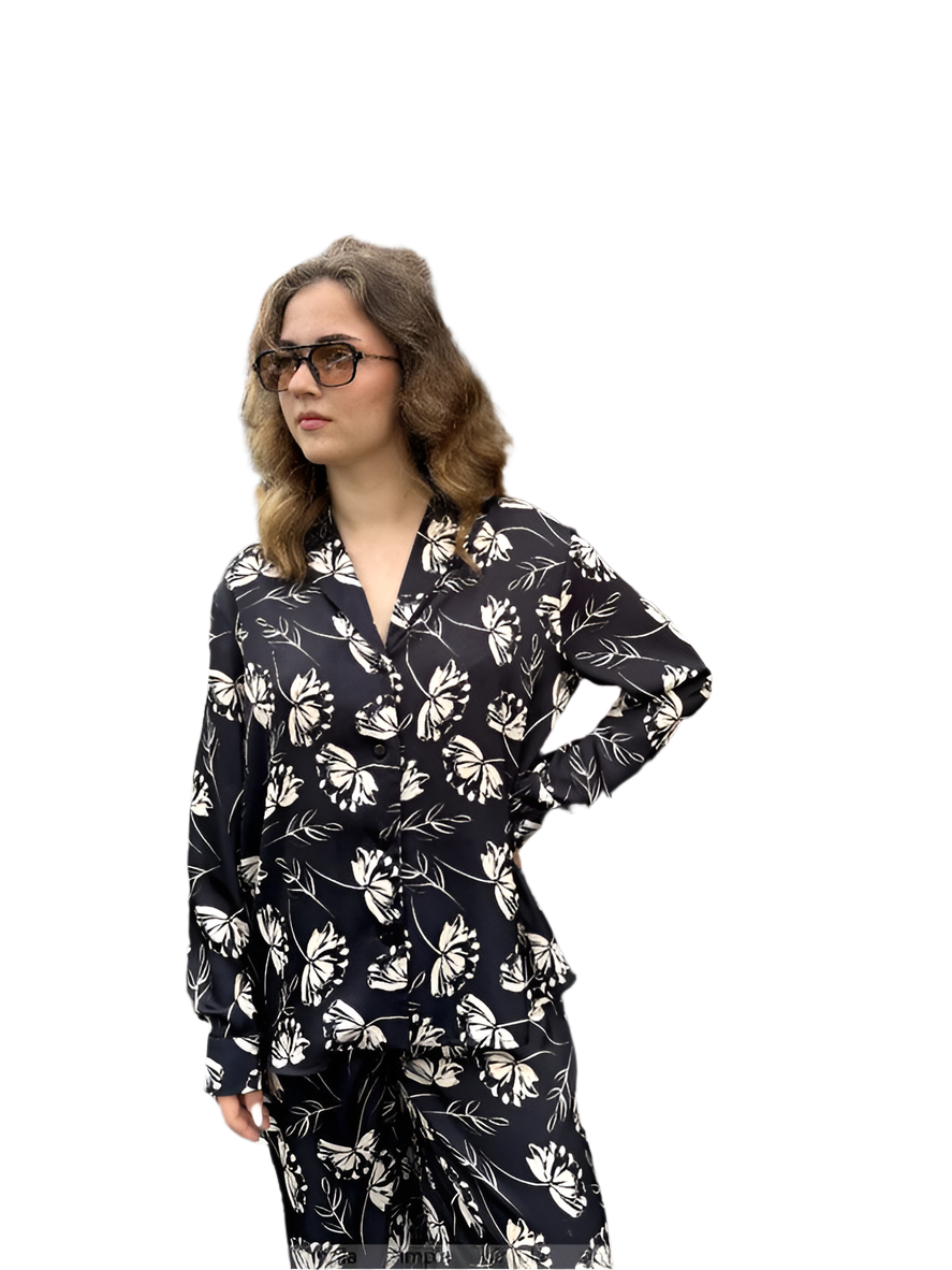 Woman wearing a black floral pajama set on a white background