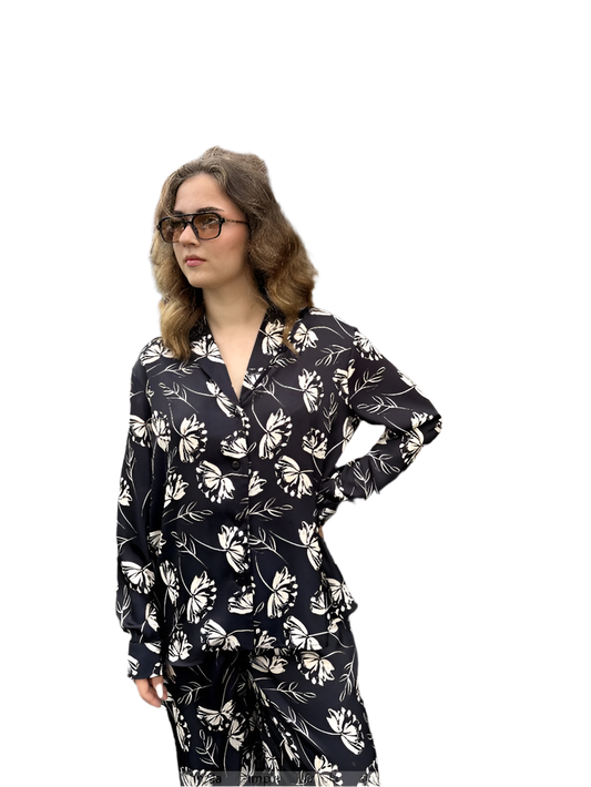 Woman wearing a black floral pajama set on a white background