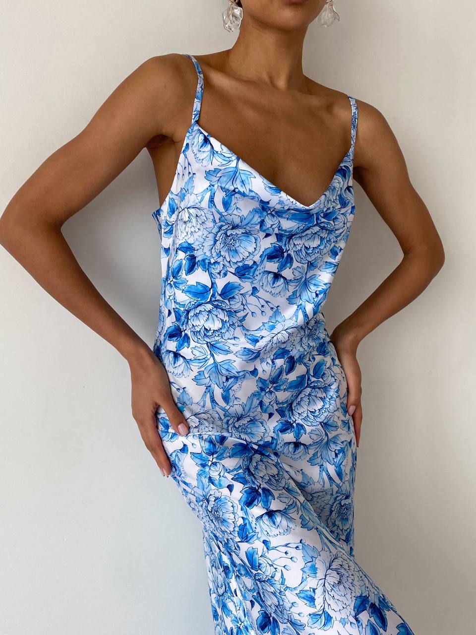 Woman wearing a blue floral dress against a plain background