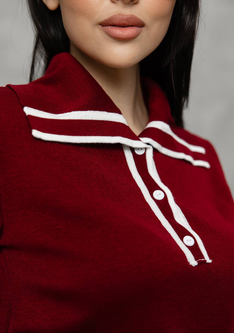 Close-up of a person wearing a red sweater with white trim and buttons.
