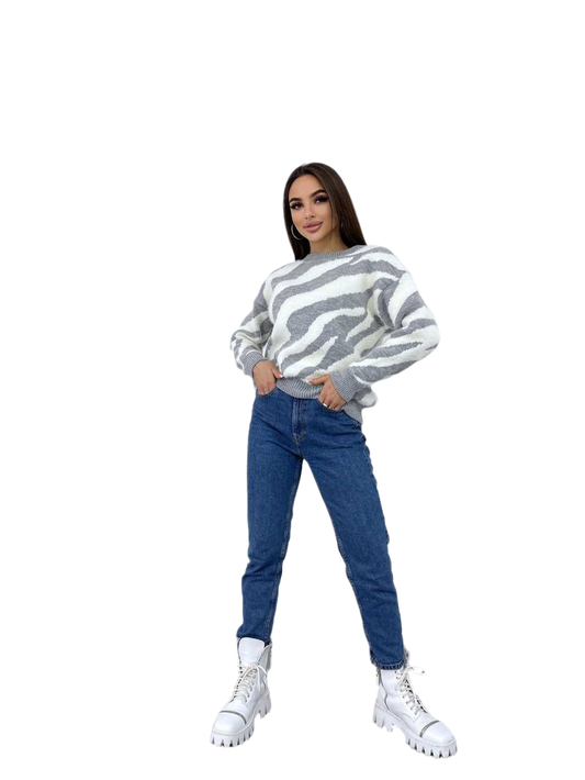 Woman wearing a striped sweater and blue jeans on a white background
