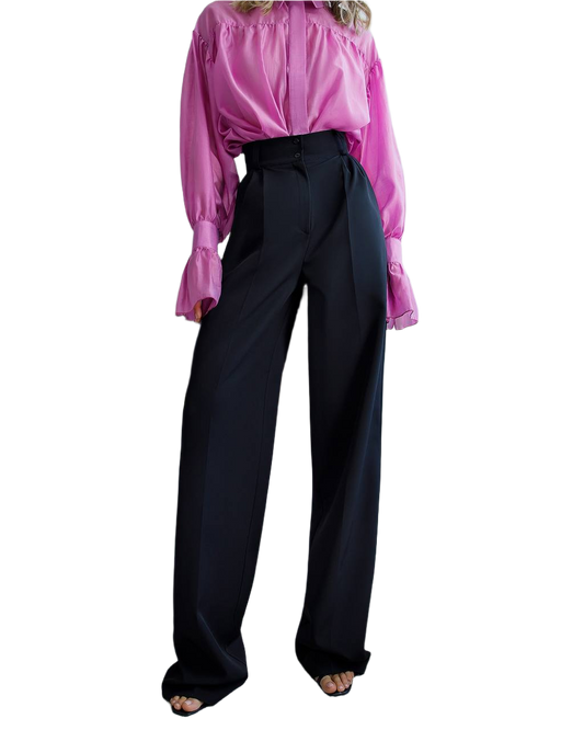 Person wearing a pink blouse and black pants on a white background