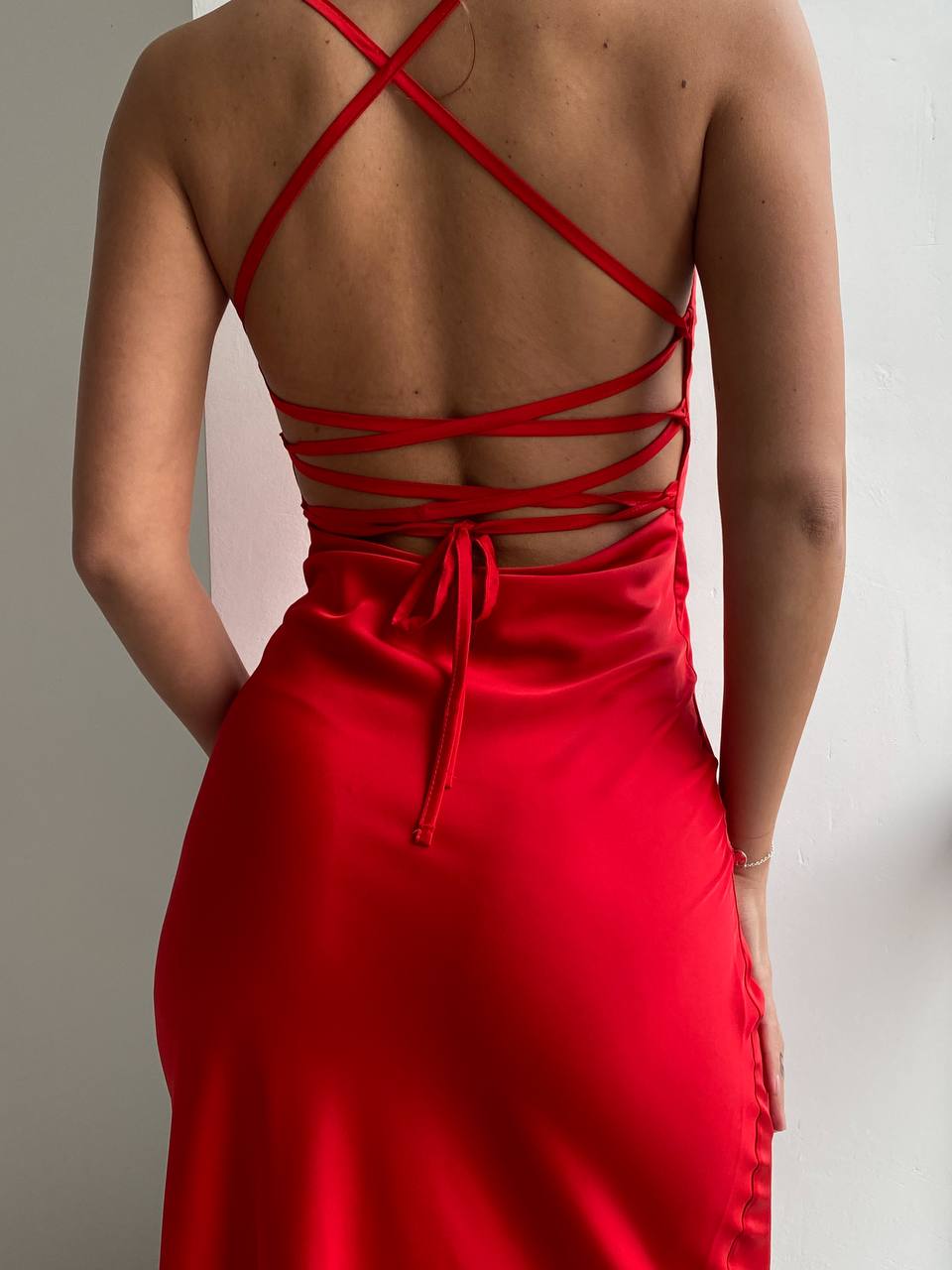 Red dress with criss-cross back straps on a neutral background