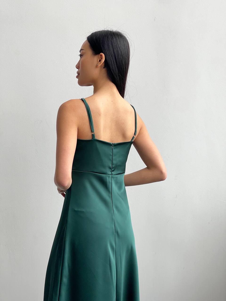 Woman wearing a green dress against a gray background