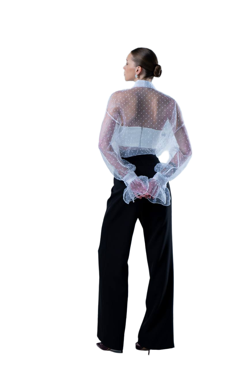 Person wearing a sheer top with a floral pattern over a black outfit on a white background