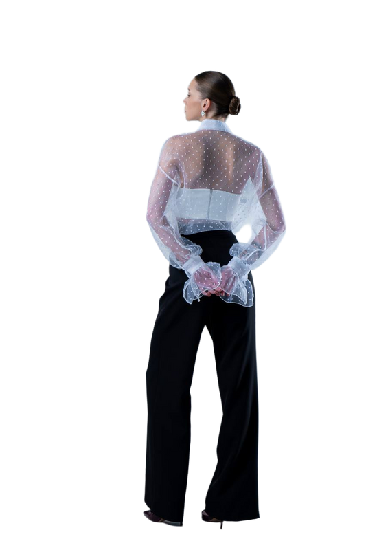 Person wearing a sheer top with a floral pattern over a black outfit on a white background