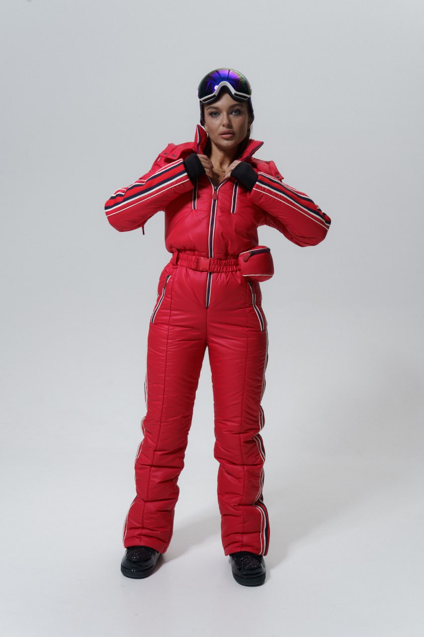 Person wearing a red ski suit with goggles on a white background