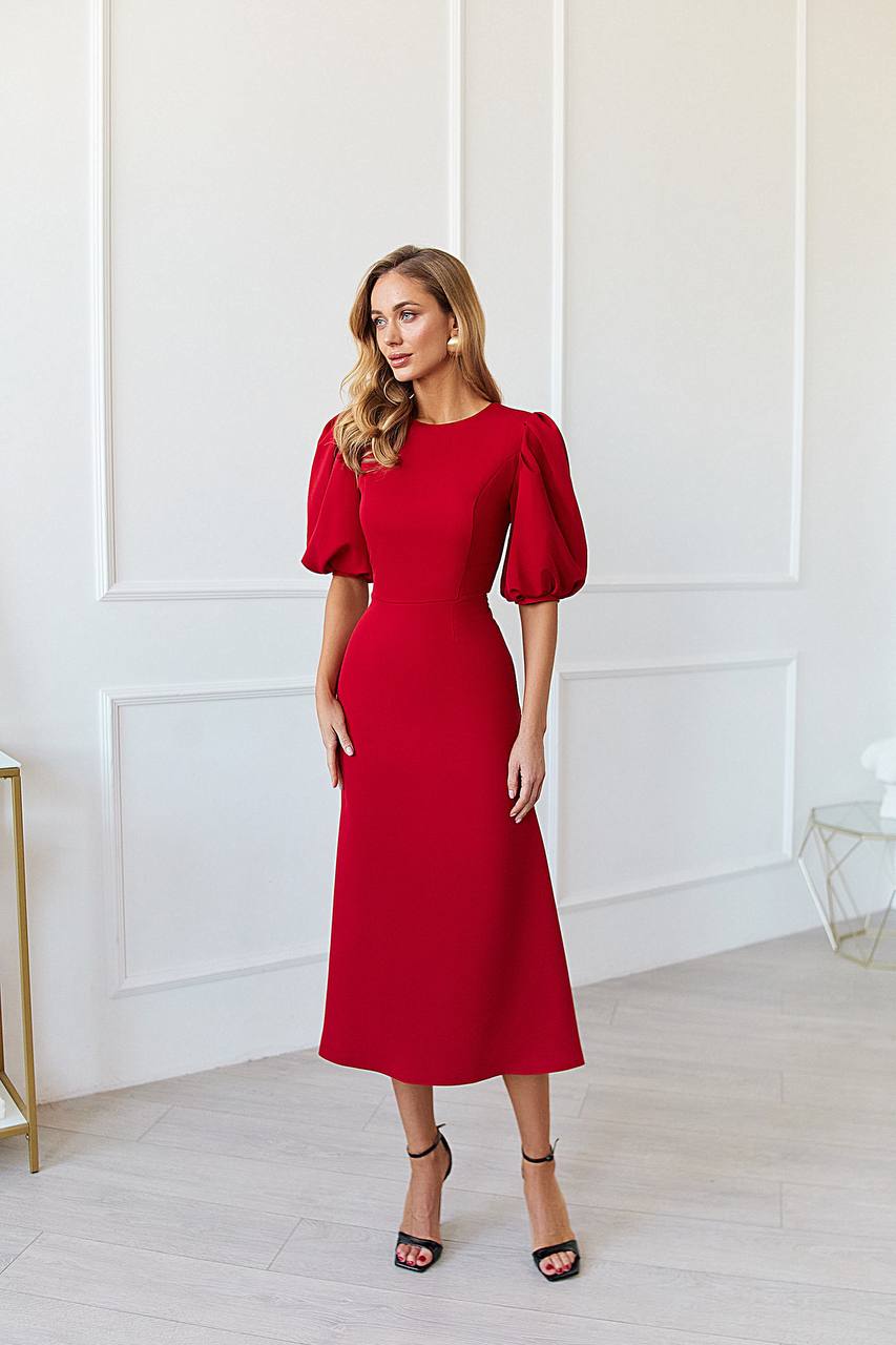 Woman wearing a red dress in a minimalistic room