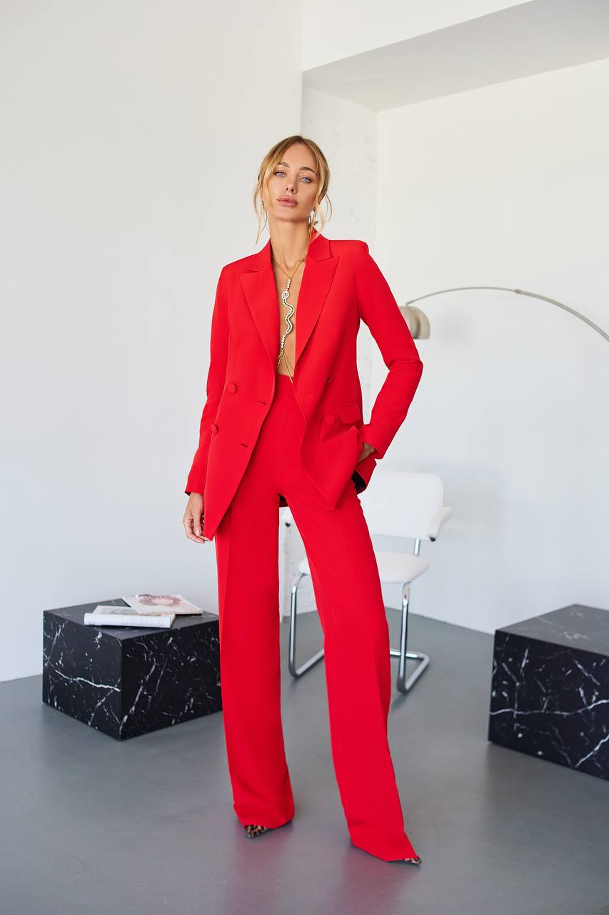 Person wearing a red suit in a modern room with white walls and black marble accents.