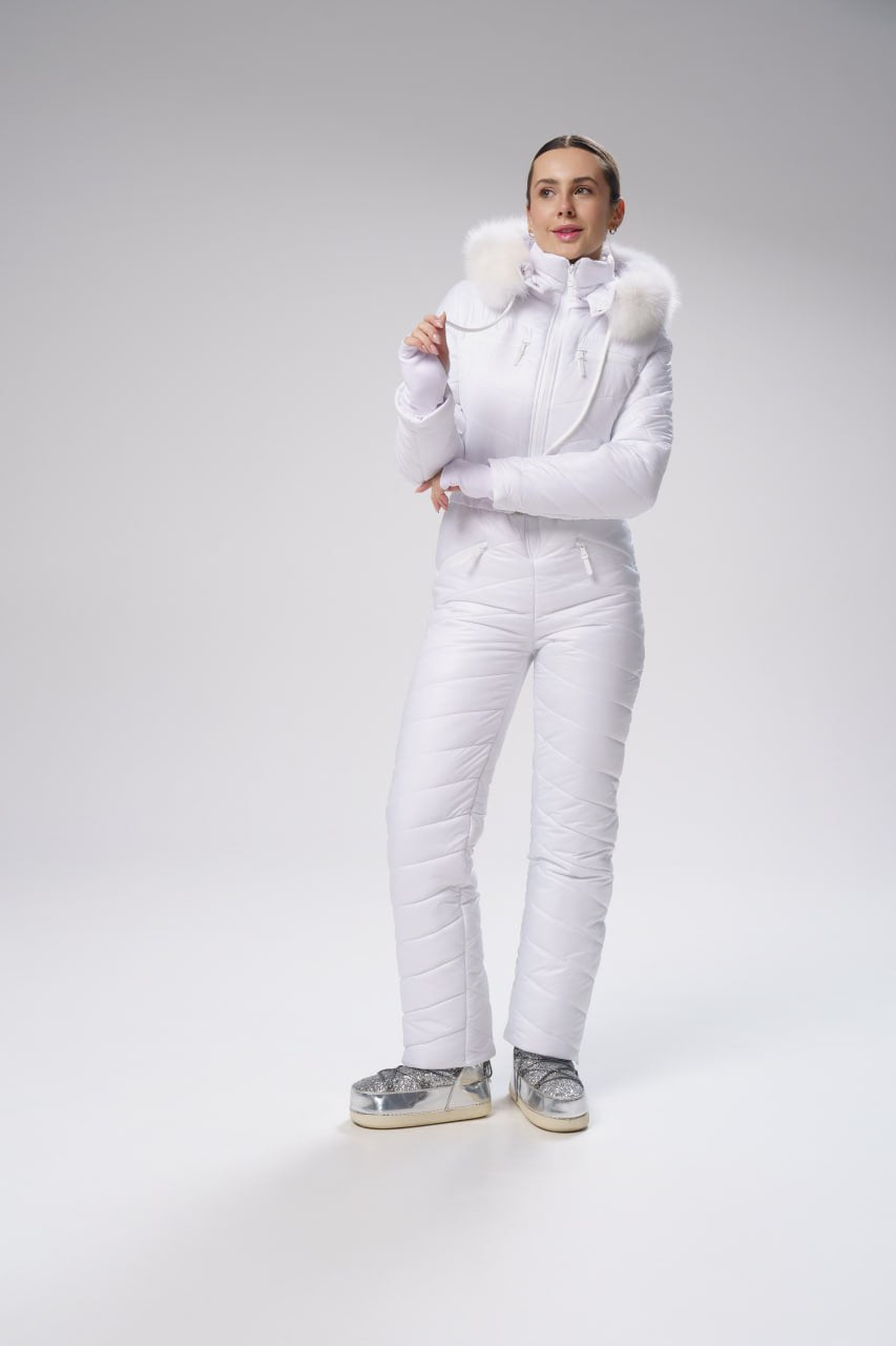 Person wearing a white puffer jacket and pants on a gray background