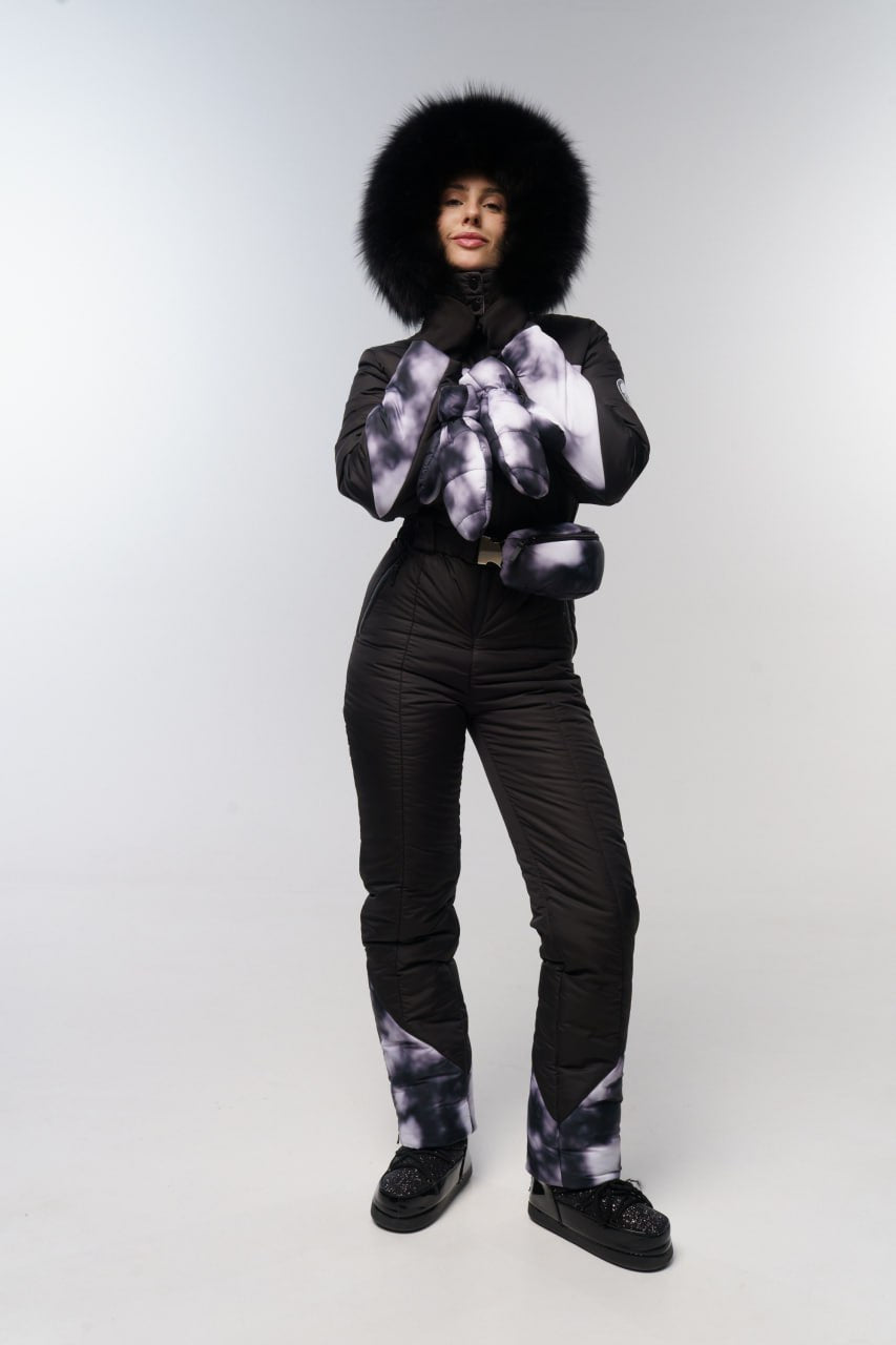 Person wearing a black snowsuit with a fur-lined hood on a white background