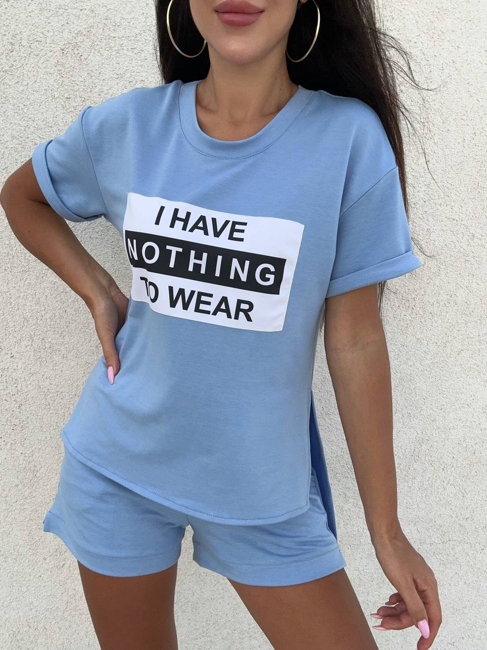 Person wearing a blue t-shirt with a humorous text design against a neutral background