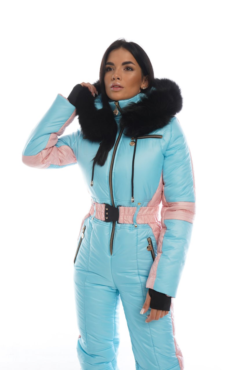 Woman wearing a light blue ski suit with black fur trim on a white background