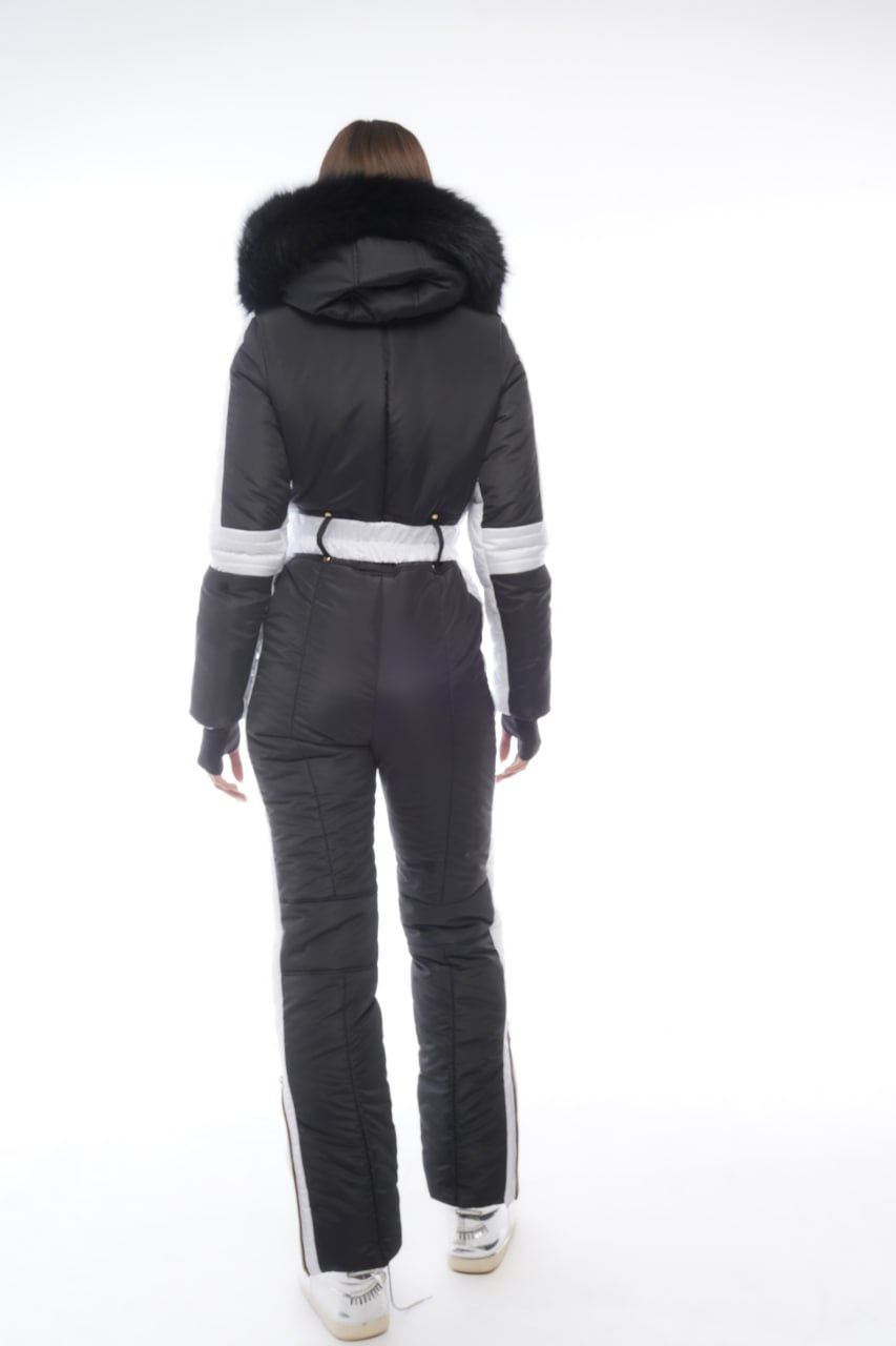 Person wearing a black ski suit with white accents on a white background