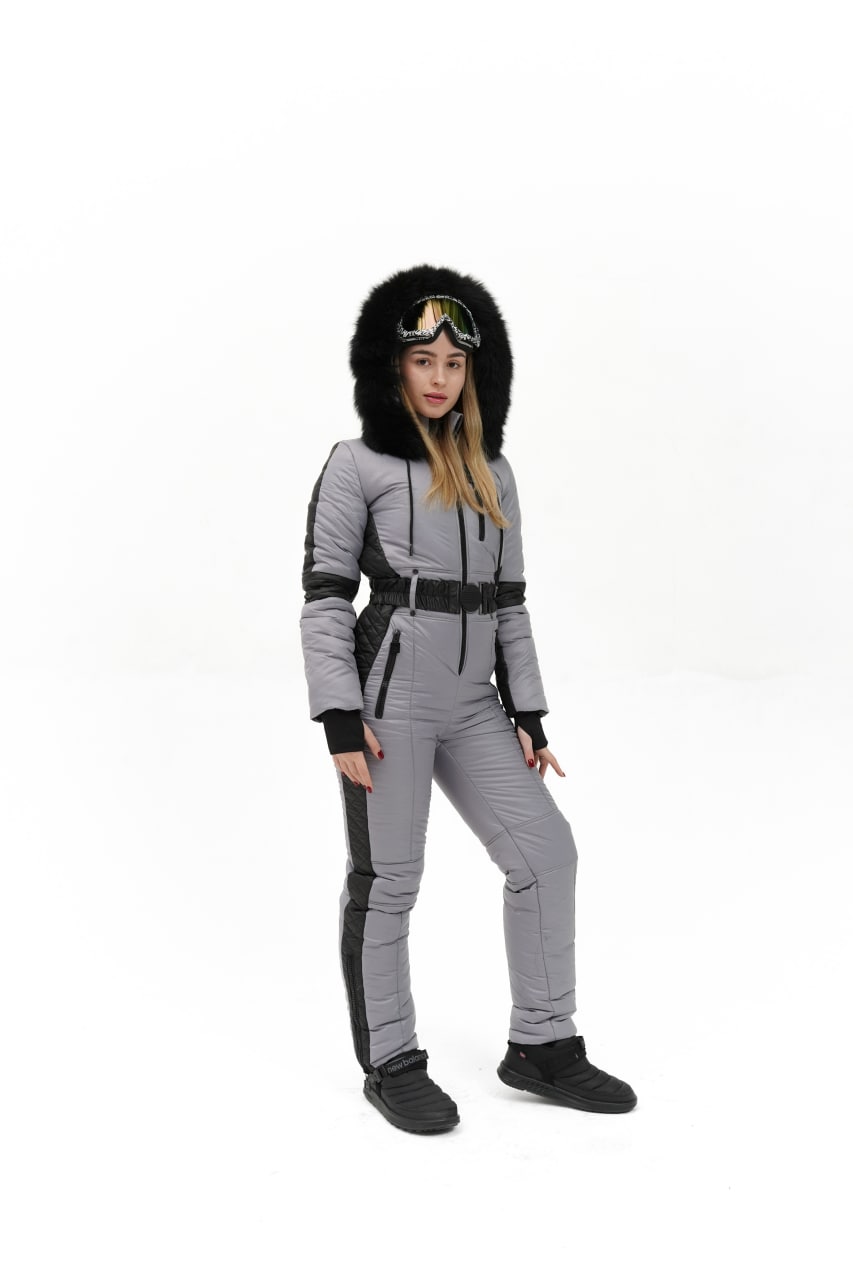 Person wearing a gray and black ski suit with a hood on a white background